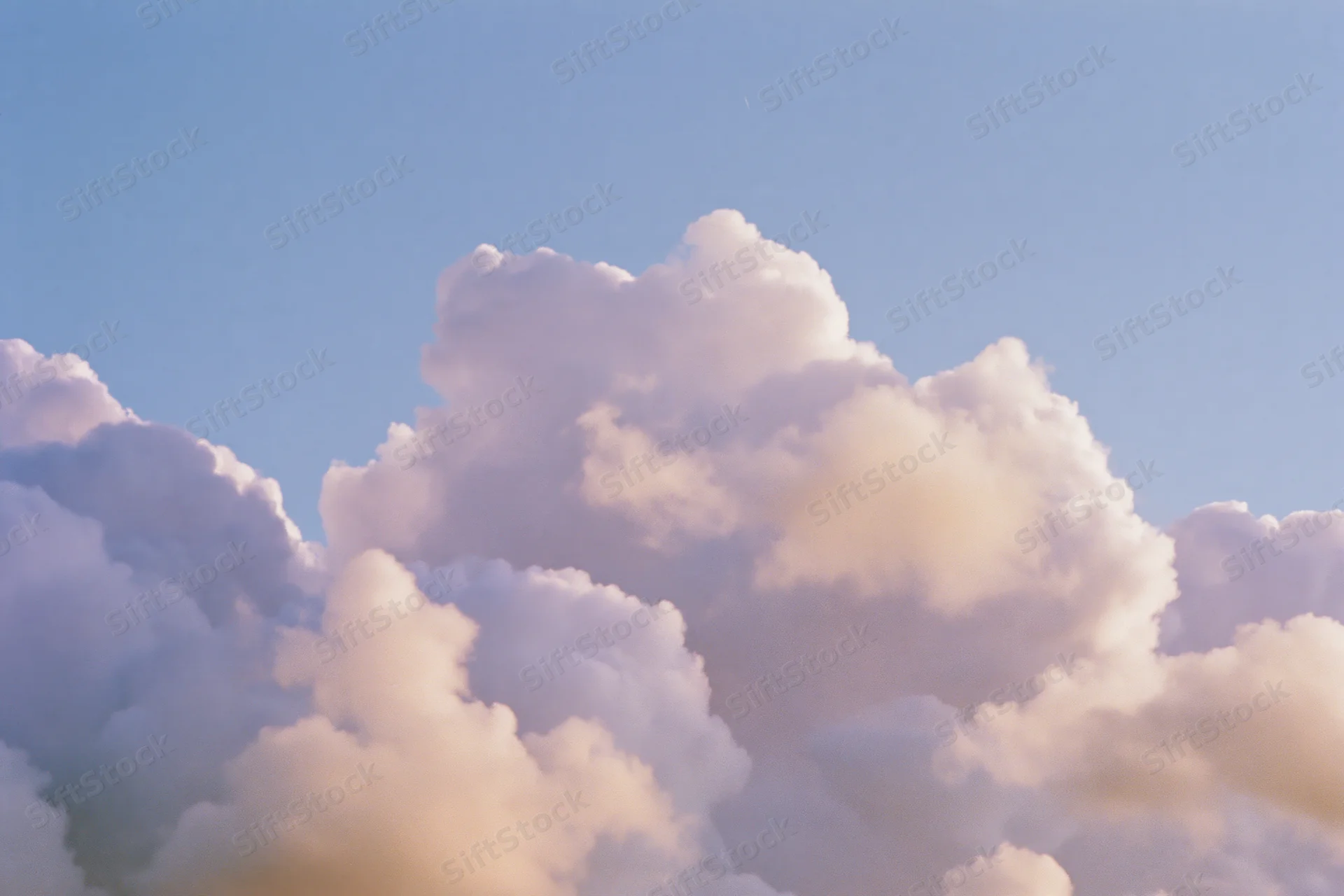 Soft cumulus clouds drifting across an open daytime sky