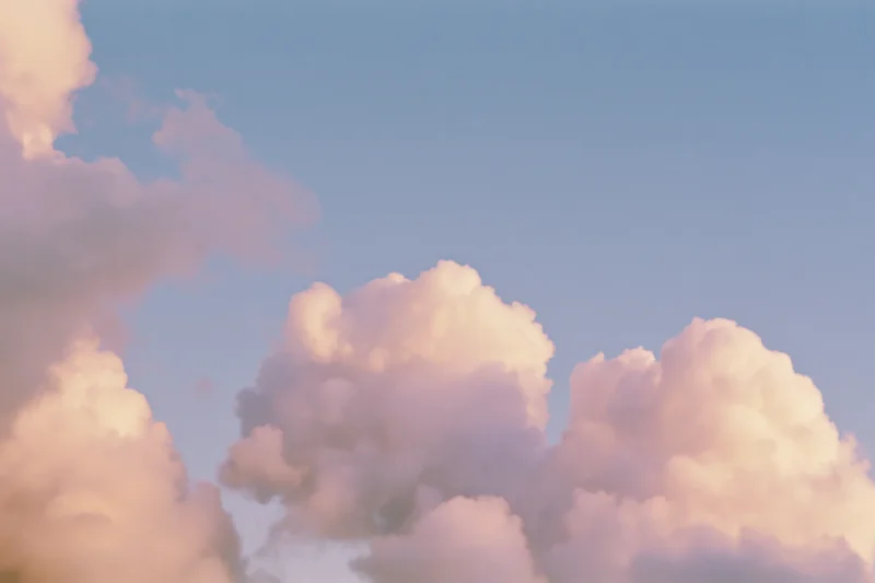 Soft cumulus clouds drifting across an open daytime sky