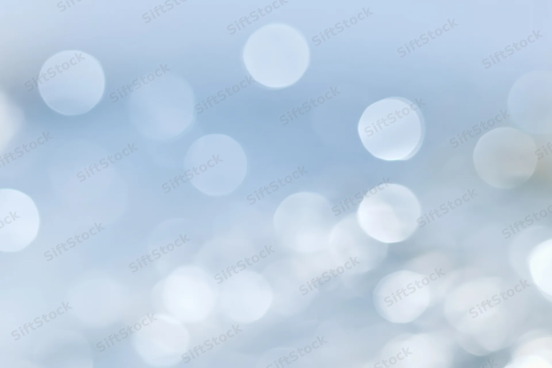 Soft out-of-focus circular lights scattered across a pale blue gradient background