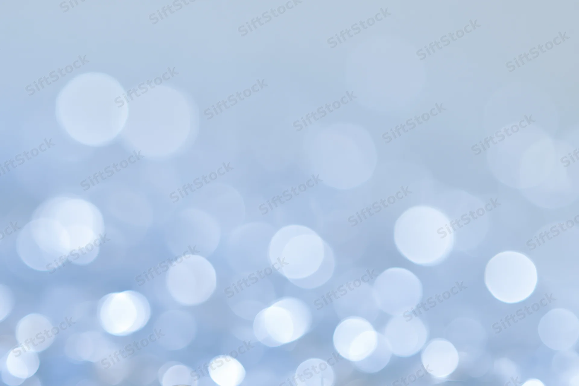 Soft out-of-focus circular lights scattered across a pale blue gradient background