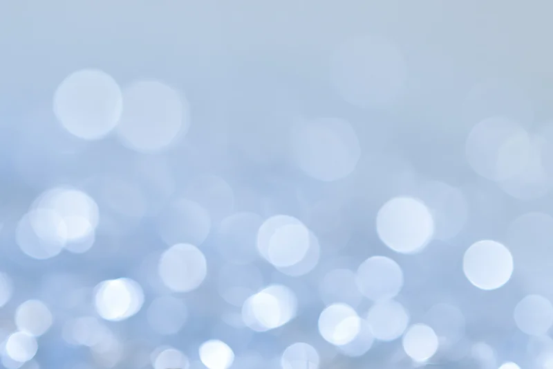 Soft out-of-focus circular lights scattered across a pale blue gradient background