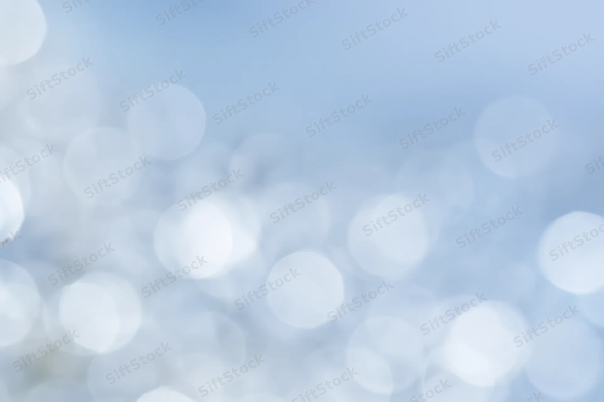 Soft out-of-focus circular lights scattered across a light blue gradient background