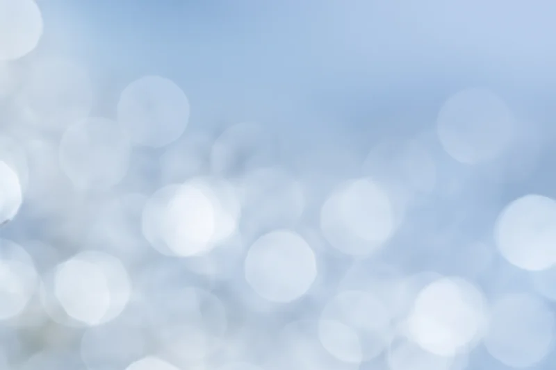 Soft out-of-focus circular lights scattered across a light blue gradient background