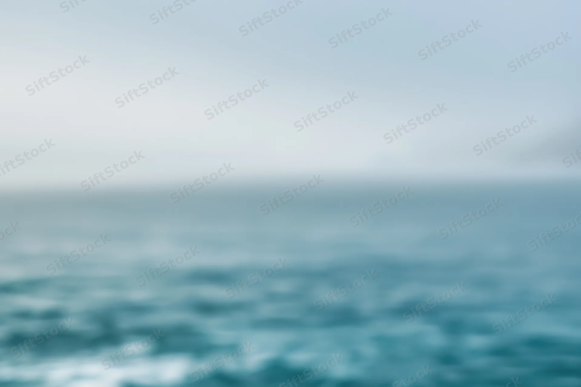 Soft blurred ocean and sky gradient background with no subject