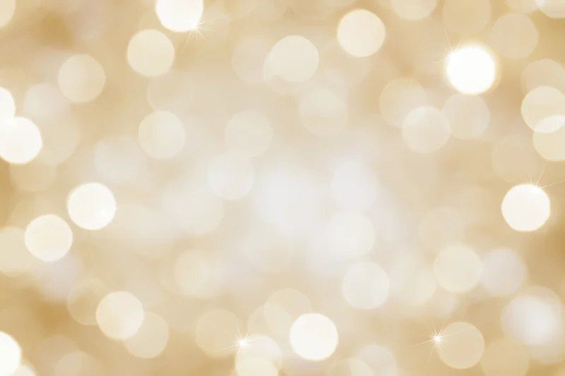 Soft golden bokeh lights scattered across a blurred background with copyspace in the center