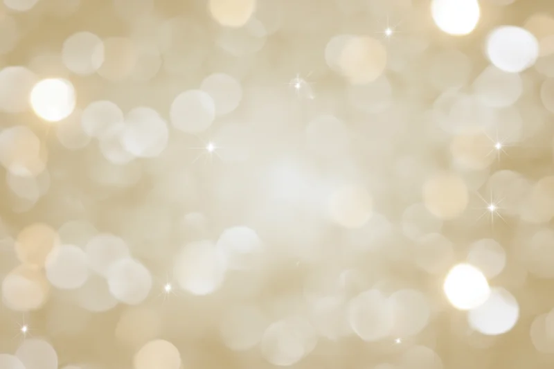 Soft out-of-focus bokeh background with scattered circular lights and sparkles in warm golden tones