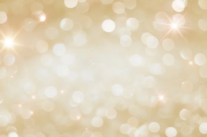 Soft golden bokeh background with scattered circular lights and starbursts, creating a festive glow