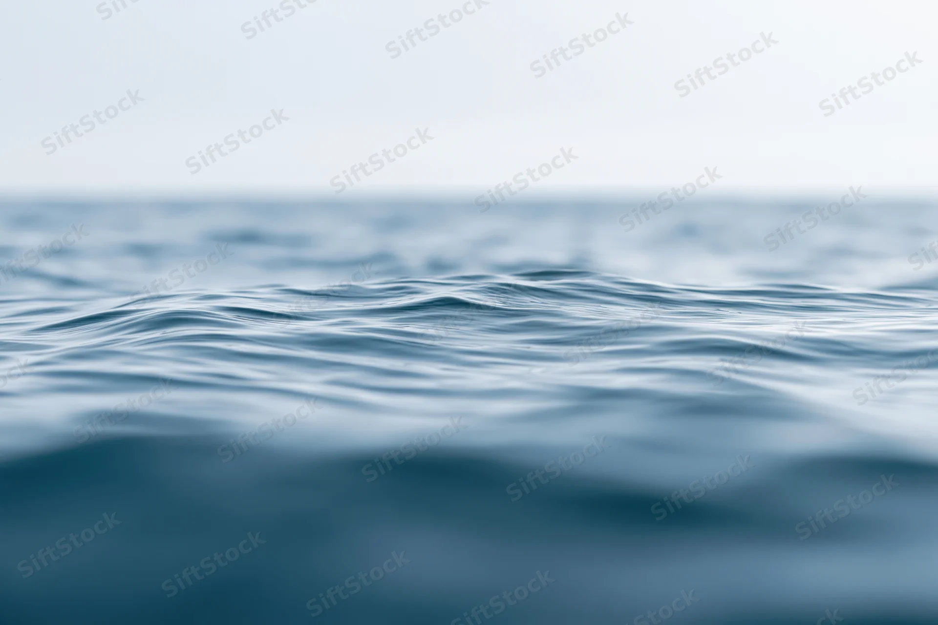 Ocean surface with gentle ripples viewed from water level, blurred foreground and background
