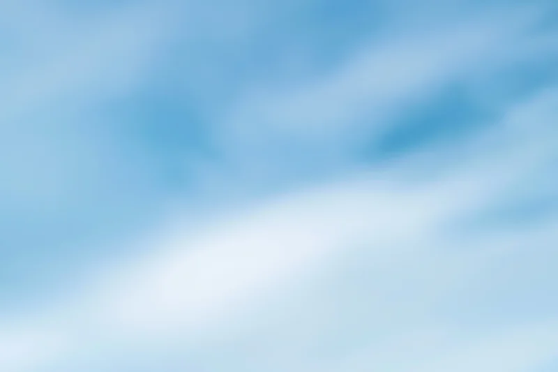Soft blurred pale blue sky with subtle cloud gradients as background
