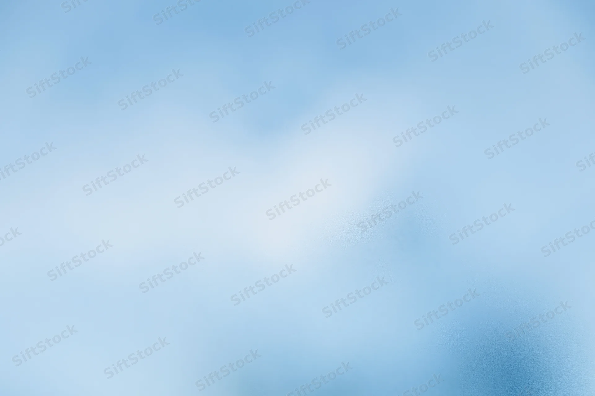 Soft blurred pale blue sky with frosted glass texture as background