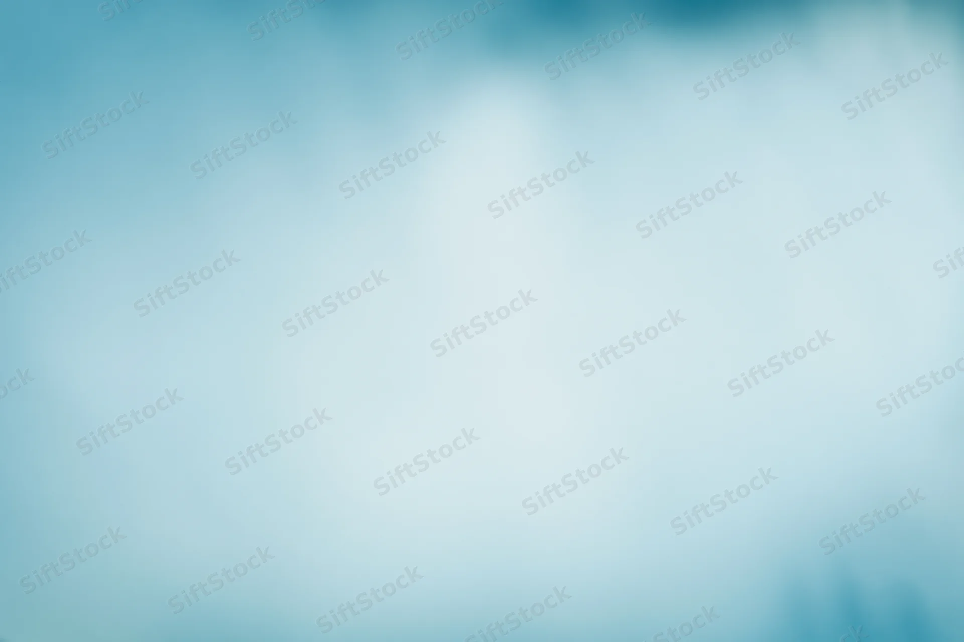 Soft out-of-focus pale blue sky or frosted glass surface with smooth gradient and copyspace