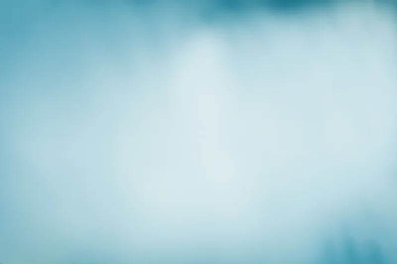 Soft out-of-focus pale blue sky or frosted glass surface with smooth gradient and copyspace