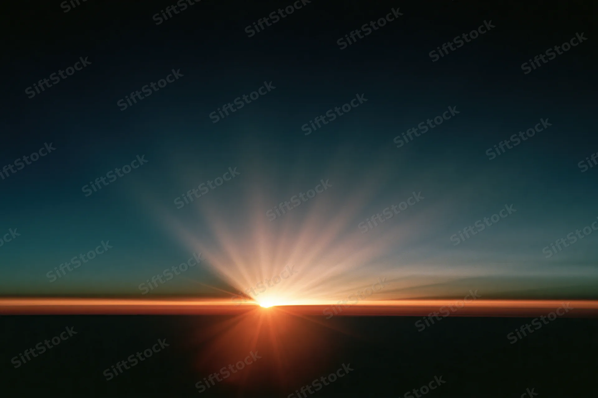Sunrise light burst radiating upward from the horizon in a wide sky view