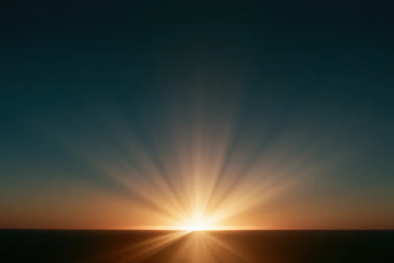 Sunrise light burst radiating upward from the horizon in a wide landscape view
