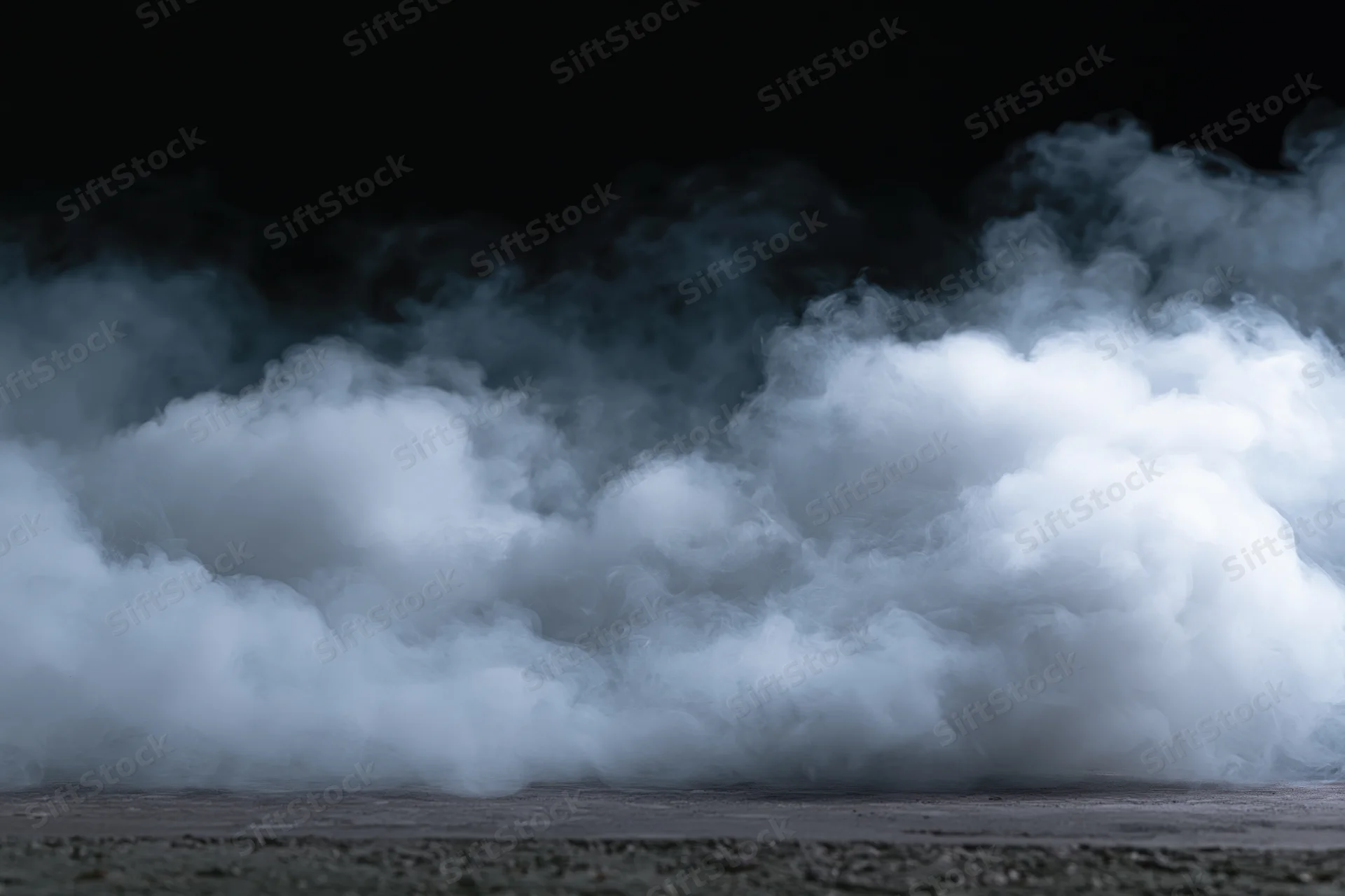 Thick white smoke rising from dark concrete floor