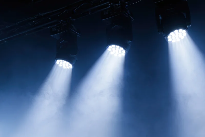 Three led par lights mounted on ceiling rig casting bright beams through smoke in dark venue