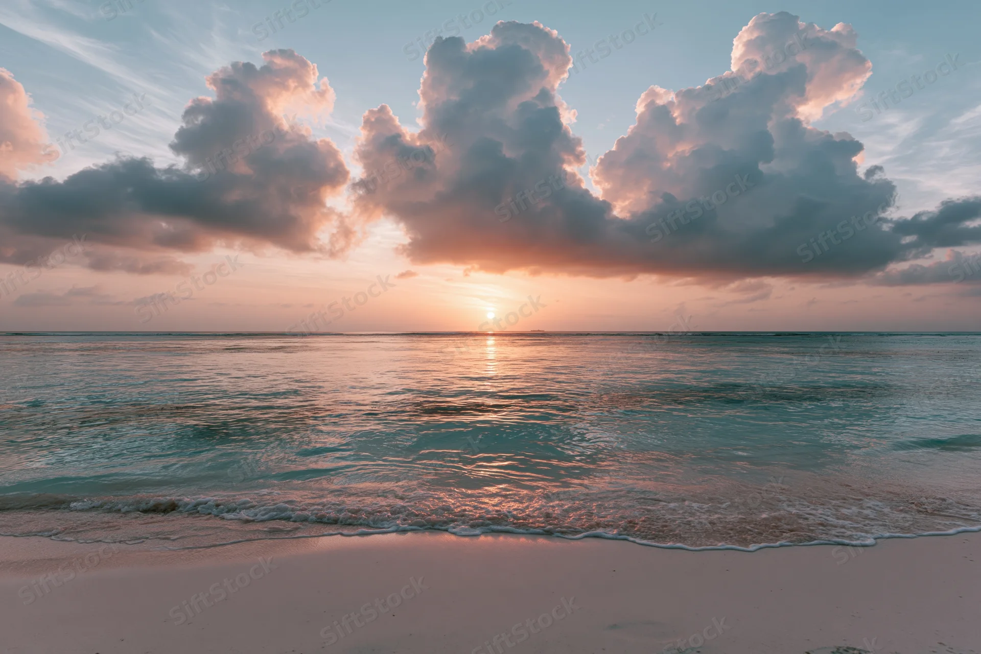 Tropical beach at sunset viewed from wet sand with waves lapping shore