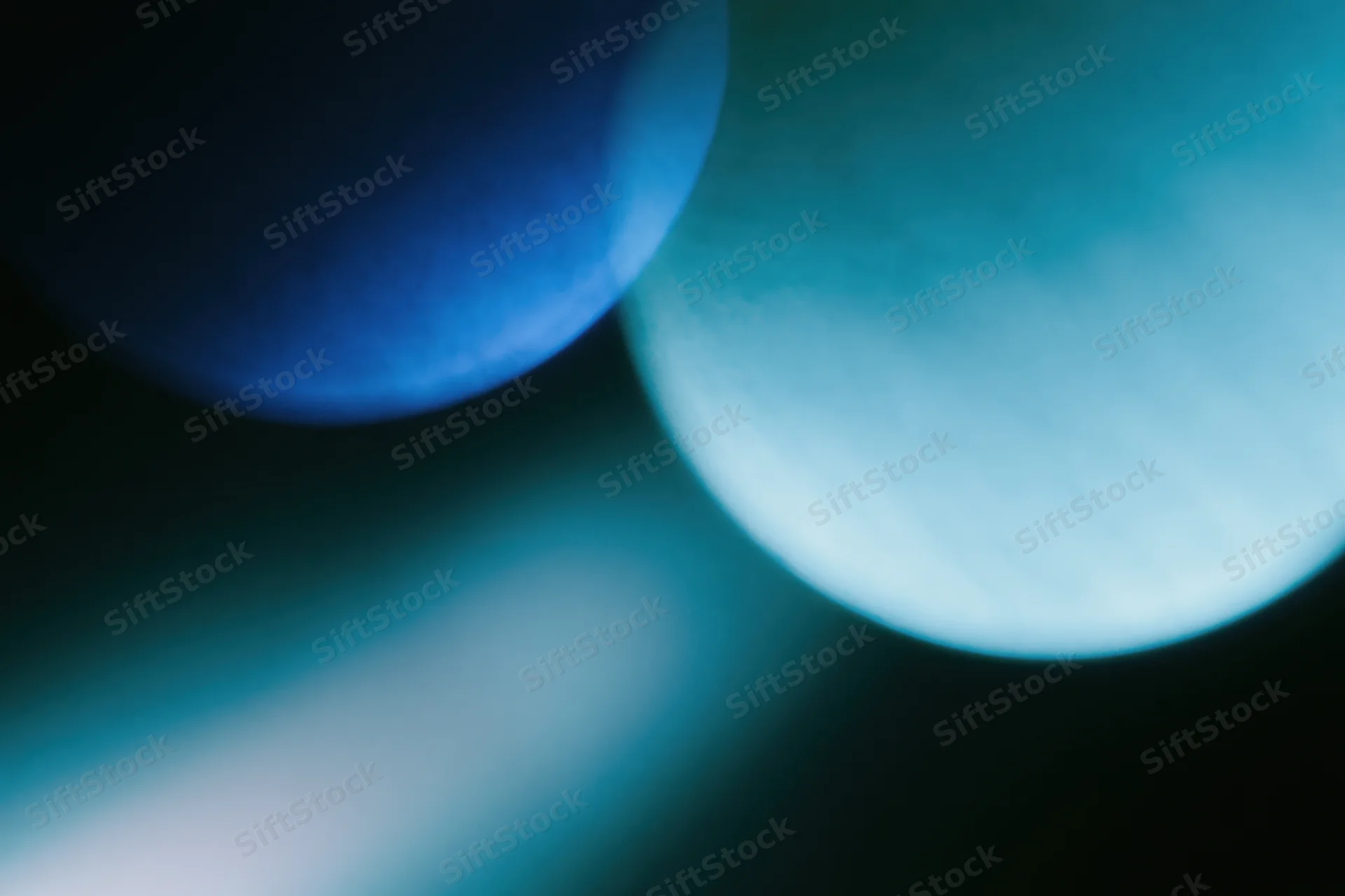 Soft overlapping light leaks in deep electric blue and teal against dark background