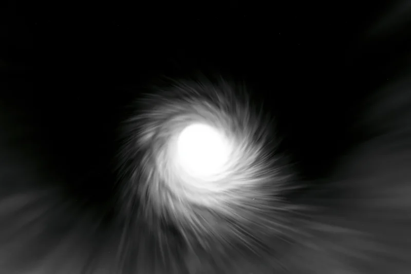 View from inside a dark circular tunnel looking toward a bright light at the center