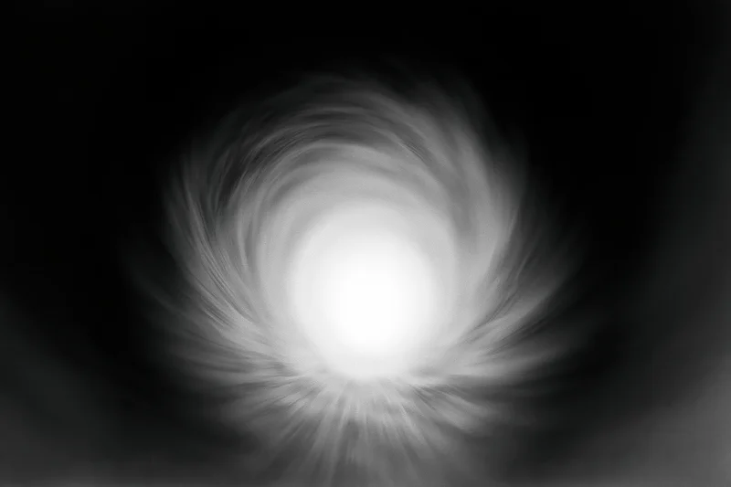 View from inside a dark circular tunnel looking toward a bright light at the end