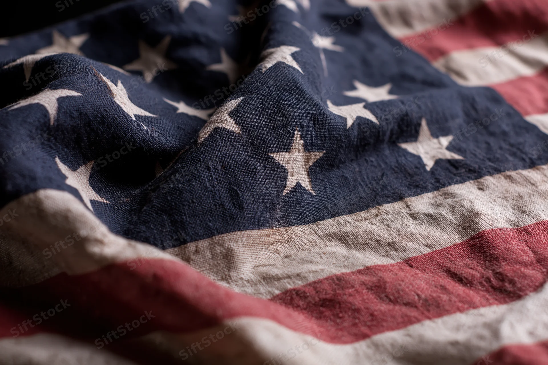 Weathered american flag with stars and stripes filling the frame in closeup view