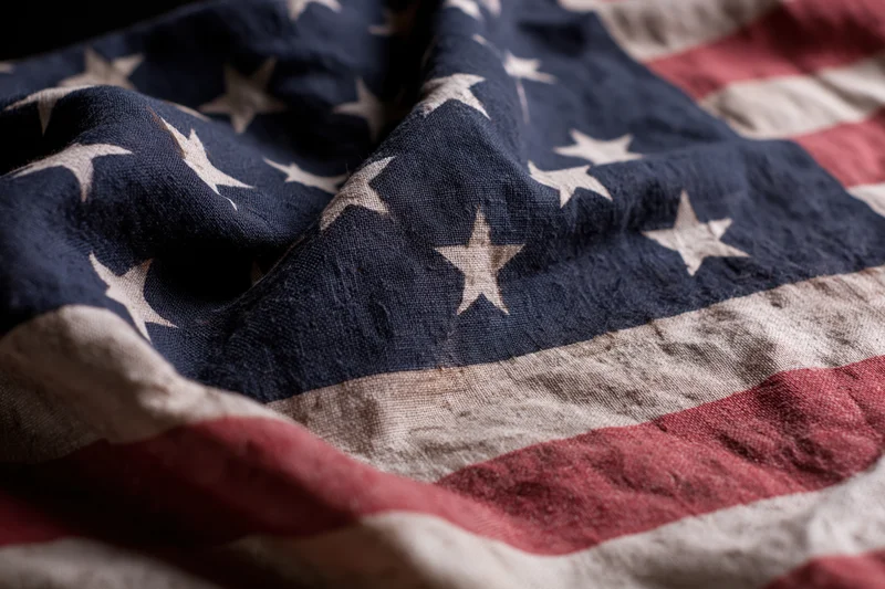 Weathered american flag with stars and stripes filling the frame in closeup view