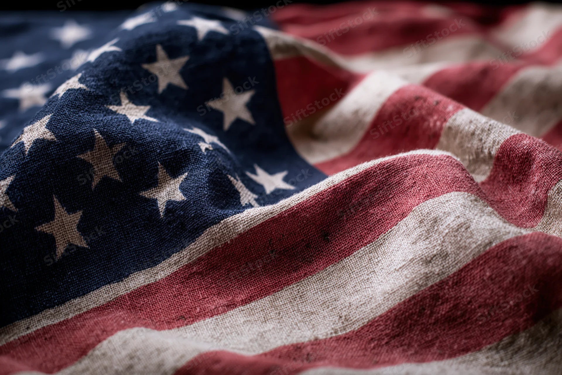 Weathered american flag filling frame with visible fabric texture and stars stripes in closeup view