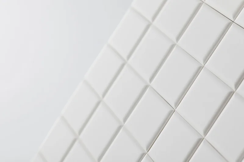 White square tiles arranged diagonally on a smooth surface