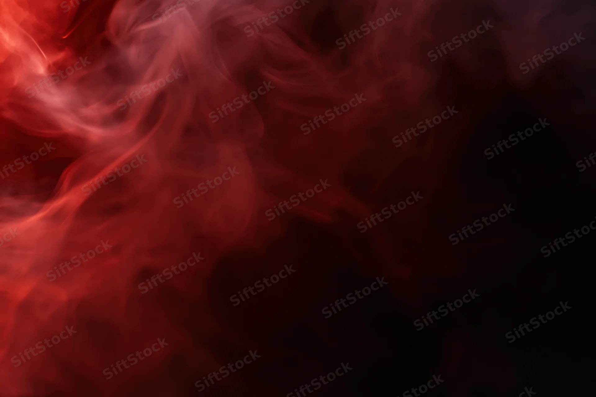 Wisps of red smoke swirling and drifting against a black background