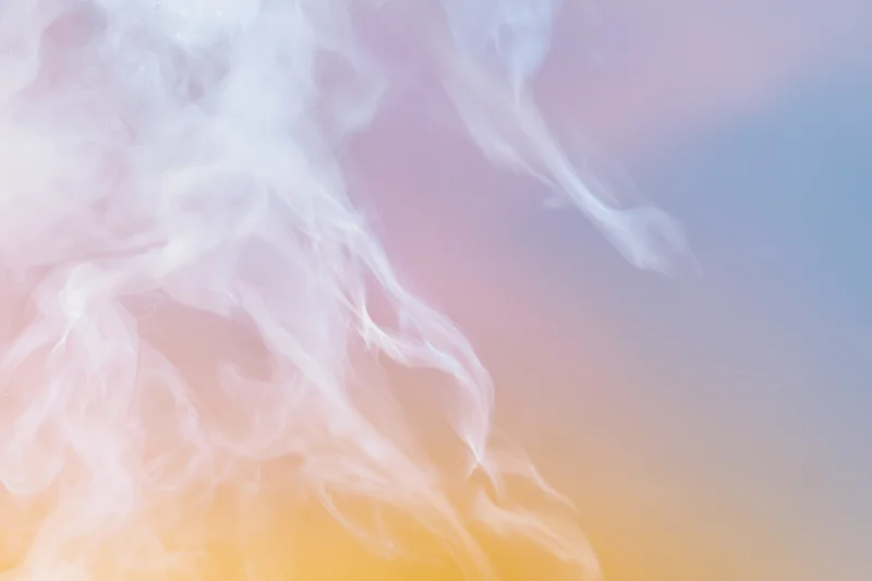 Wispy white smoke tendrils drifting and curling against a soft pastel gradient background