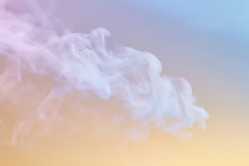 Wispy white smoke tendrils drifting and curling against a soft pastel gradient background