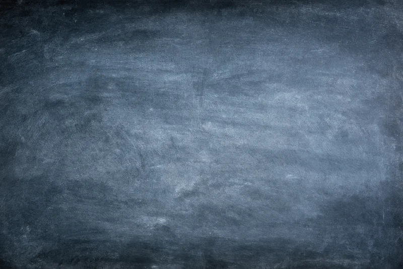 Worn chalkboard surface filling the frame with smudged residue and texture