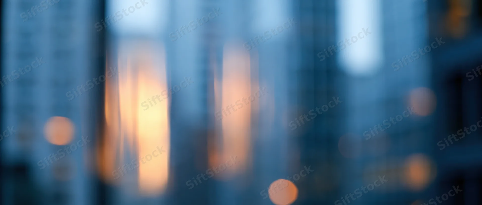 Blurred city skyline with glowing windows at dusk