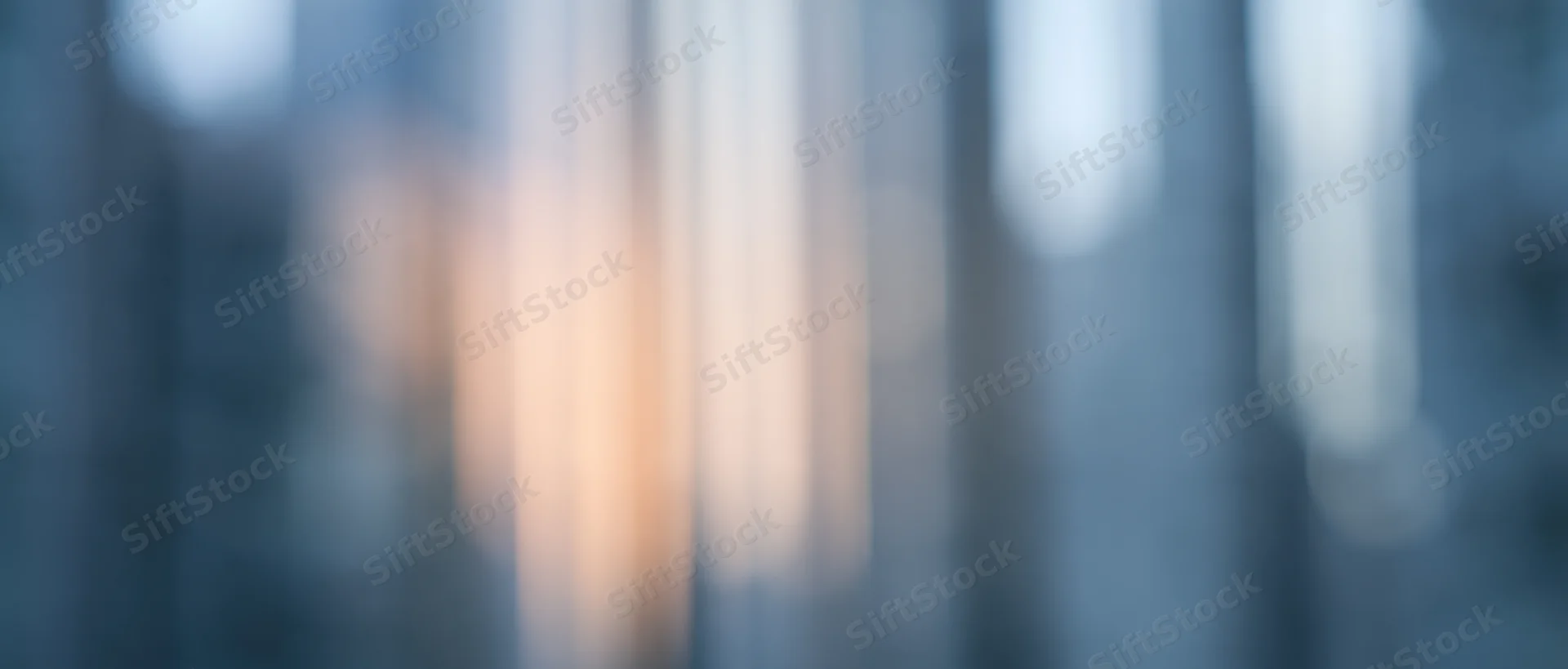 Blurred vertical light streaks in soft focus with warm and cool tones creating an abstract background