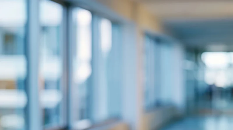 Blurred view of an office hallway with glass partitions and soft ambient light