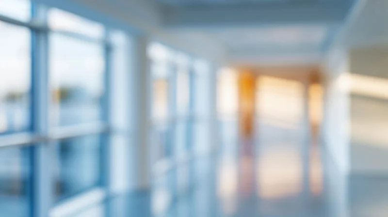Blurred view of a modern office hallway with glass windows and bright lighting