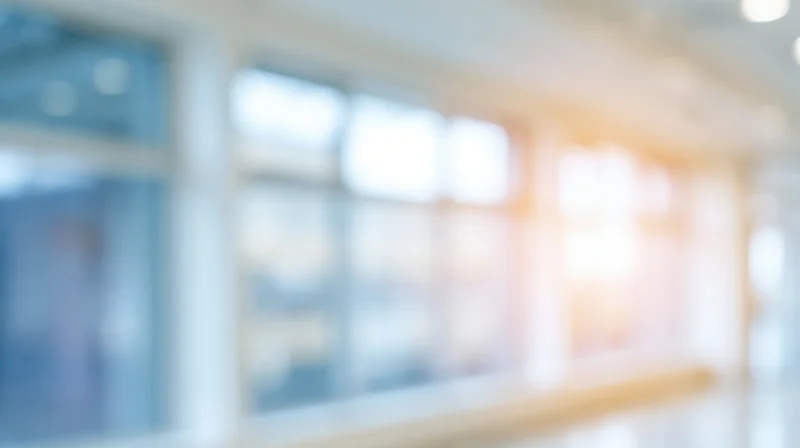 Blurred interior of modern office space with large windows and soft natural light