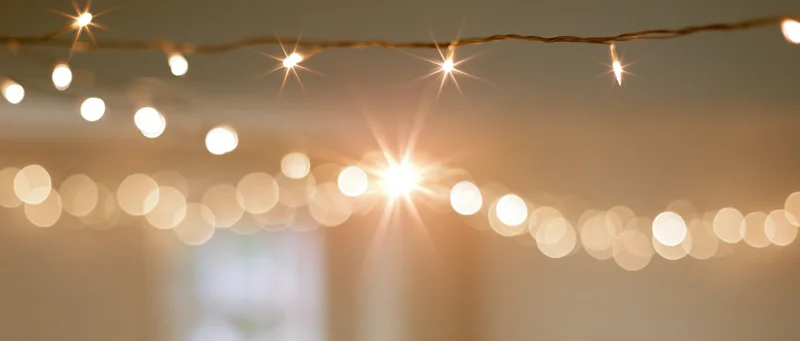 String lights hanging across ceiling with warm glow and bokeh effect in soft focus interior