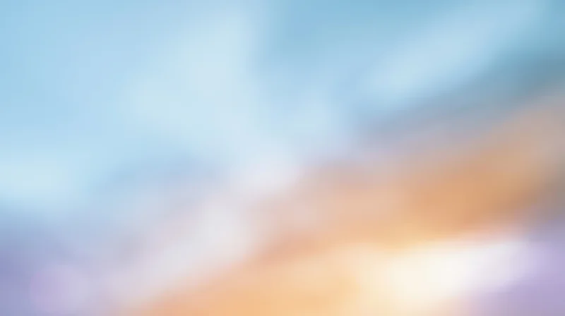 Soft blurred sky with warm sunset glow and blue clouds at twilight horizon