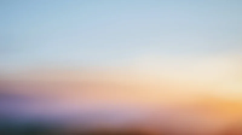 Soft gradient sky at dusk with warm orange and cool blue tones transitioning across the horizon