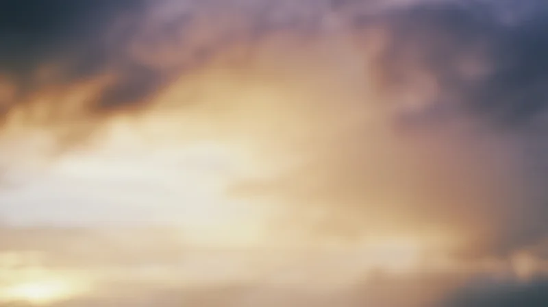 Soft golden light glowing through hazy clouds at dusk