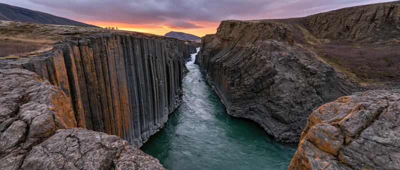 River flowing through columnar basalt canyon at sunset