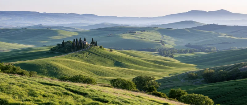 Rolling green hills with cypress trees and a farmhouse in tuscany at sunrise