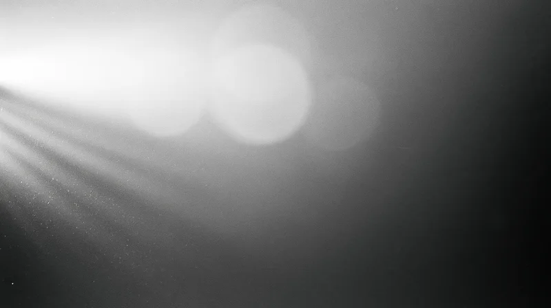 Soft light beams and bokeh circles in a monochrome abstract background with copyspace
