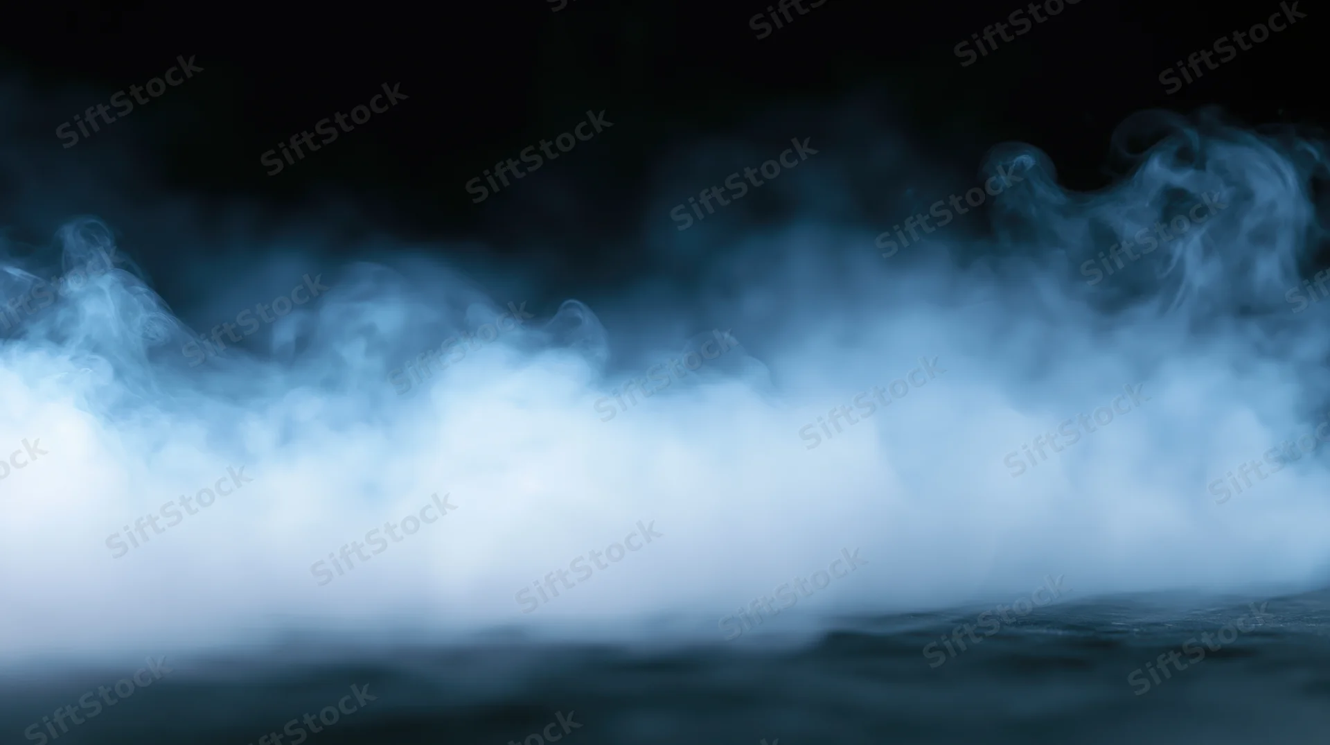 Swirling blue smoke rising from a dark surface in low light