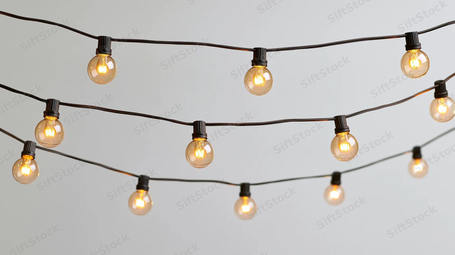 String of warm glowing bulbs arranged in rows against a plain background