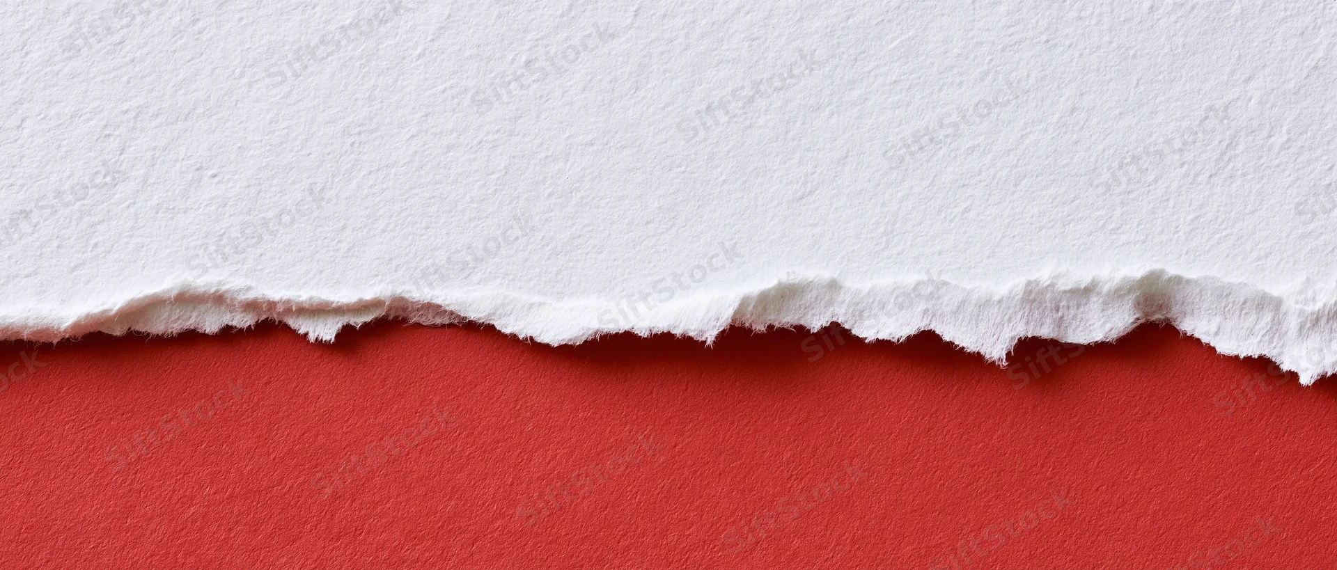 Torn white paper revealing red surface below