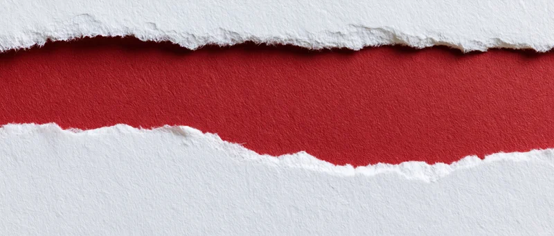 Torn white paper revealing a red textured strip beneath
