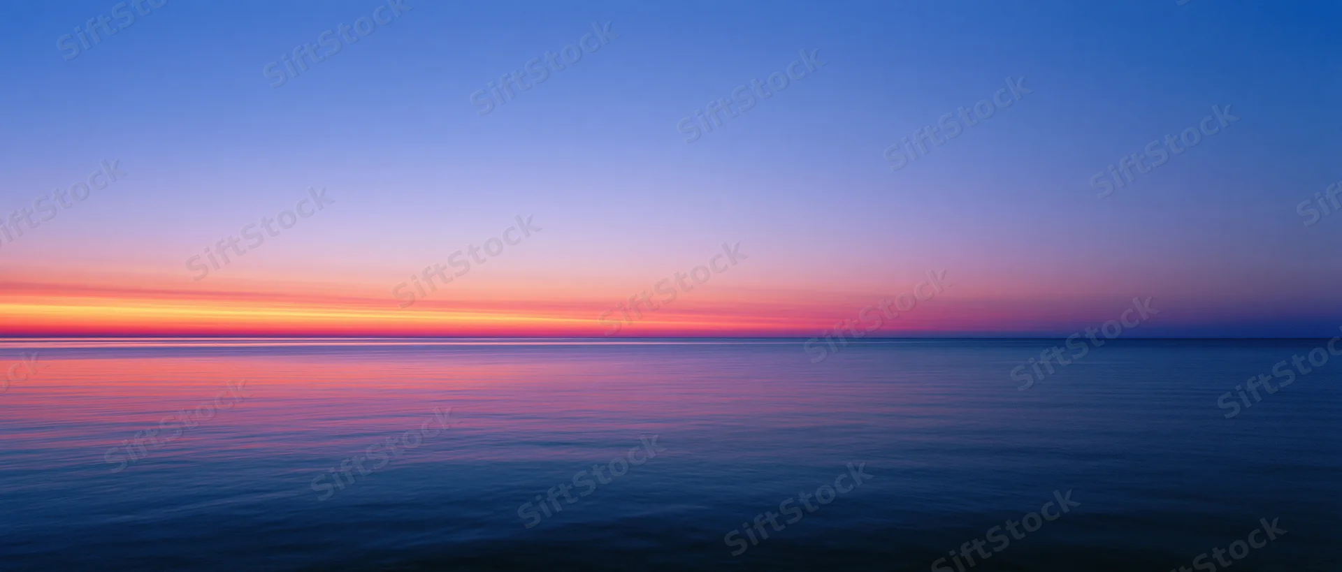 Sunset over calm ocean with colorful sky reflection