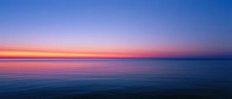 Sunset over calm ocean with colorful sky reflection